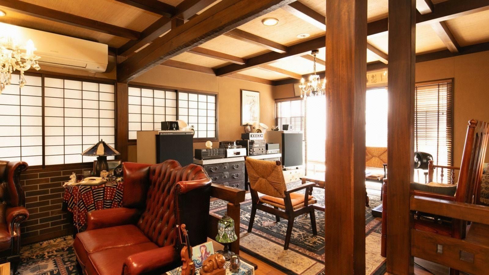 A traditional Japanese-style living room with tatami flooring, a low wooden table, and a sofa.