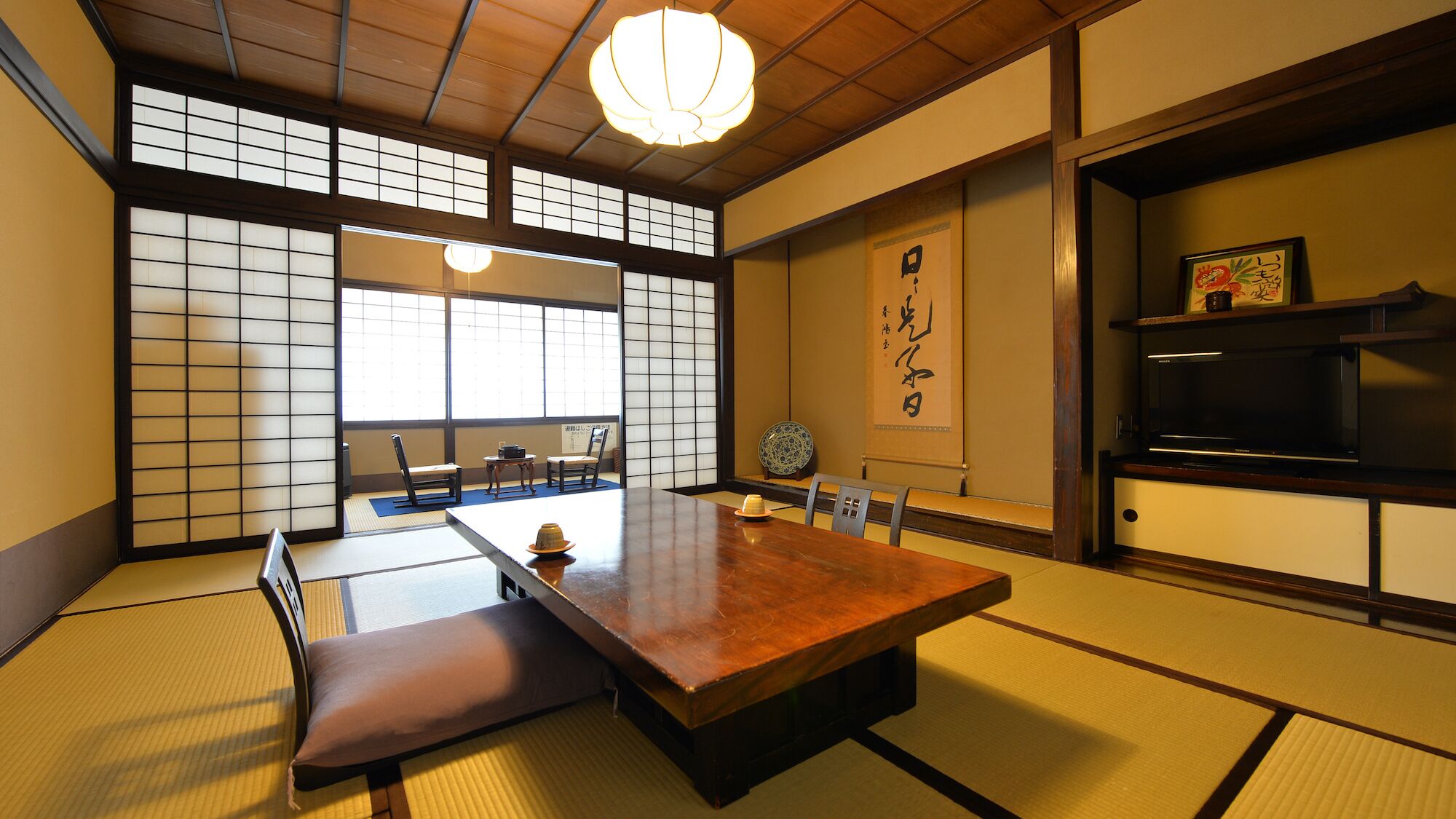 Een traditionele Japanse kamer met tatami vloeren, een lage tafel en schuifdeuren.