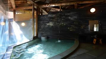 A spa area with a hot tub, wooden beams, and a large mirror.