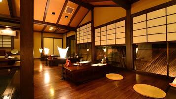 A traditional Japanese-style room with tatami flooring, a low wooden table, and sliding doors.