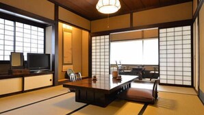 A traditional Japanese-style room with tatami flooring, a low table, and sliding doors. - Ryokan Sugimoto (Matsumoto)