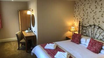 A hotel room with a bed, a desk, and a chair.