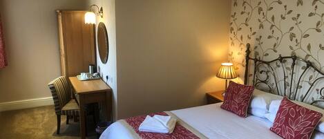Een hotelkamer met een bed, een bureau en een stoel.