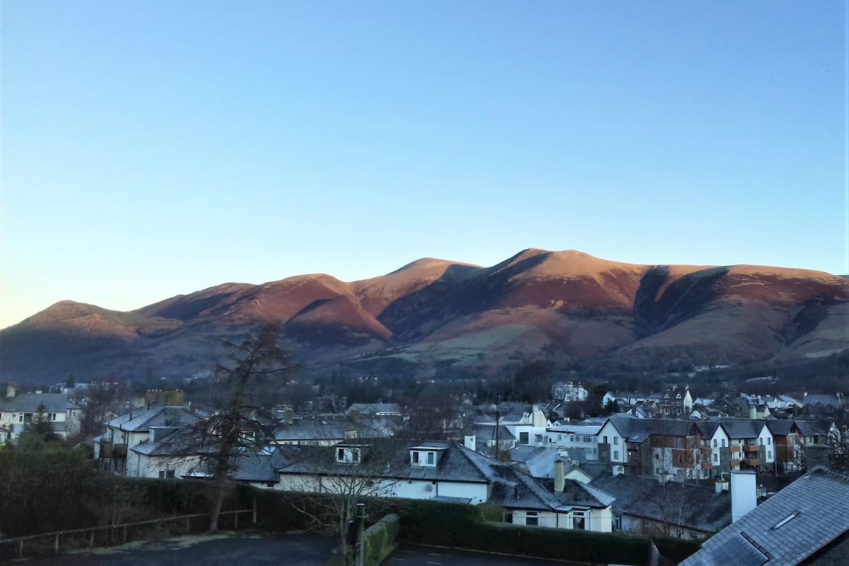 Une ville avec des maisons et, en arrière-plan, une chaîne de montagnes.