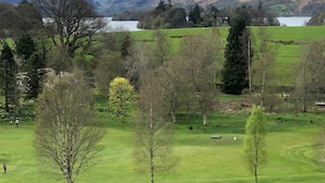A golf course with a lake and mountains in the background.