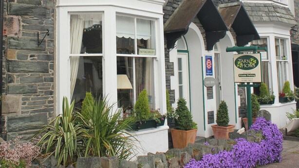 A stone building with a sign for 'Tarn Hows' indicating private parking. - Tarn Hows Guest House (Keswick)