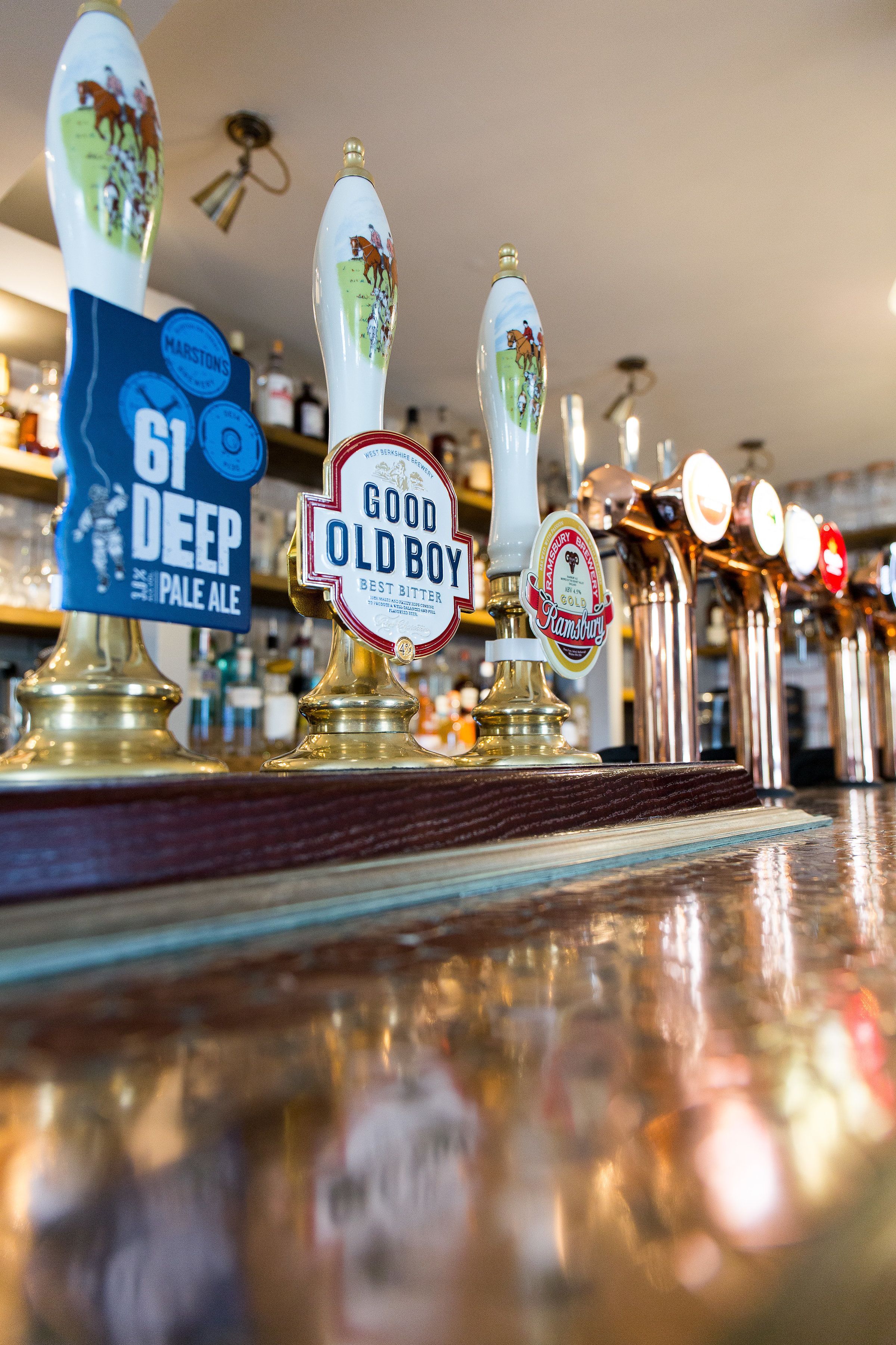 Un bancone bar con diverse spine per birra, tra cui etichette per '61 Deep Pale Ale' e 'Good Old Boy Best Bitter'.