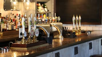 Eine Bar mit mehreren Zapfhähnen und einer Auswahl an Spirituosenflaschen im Hintergrund.