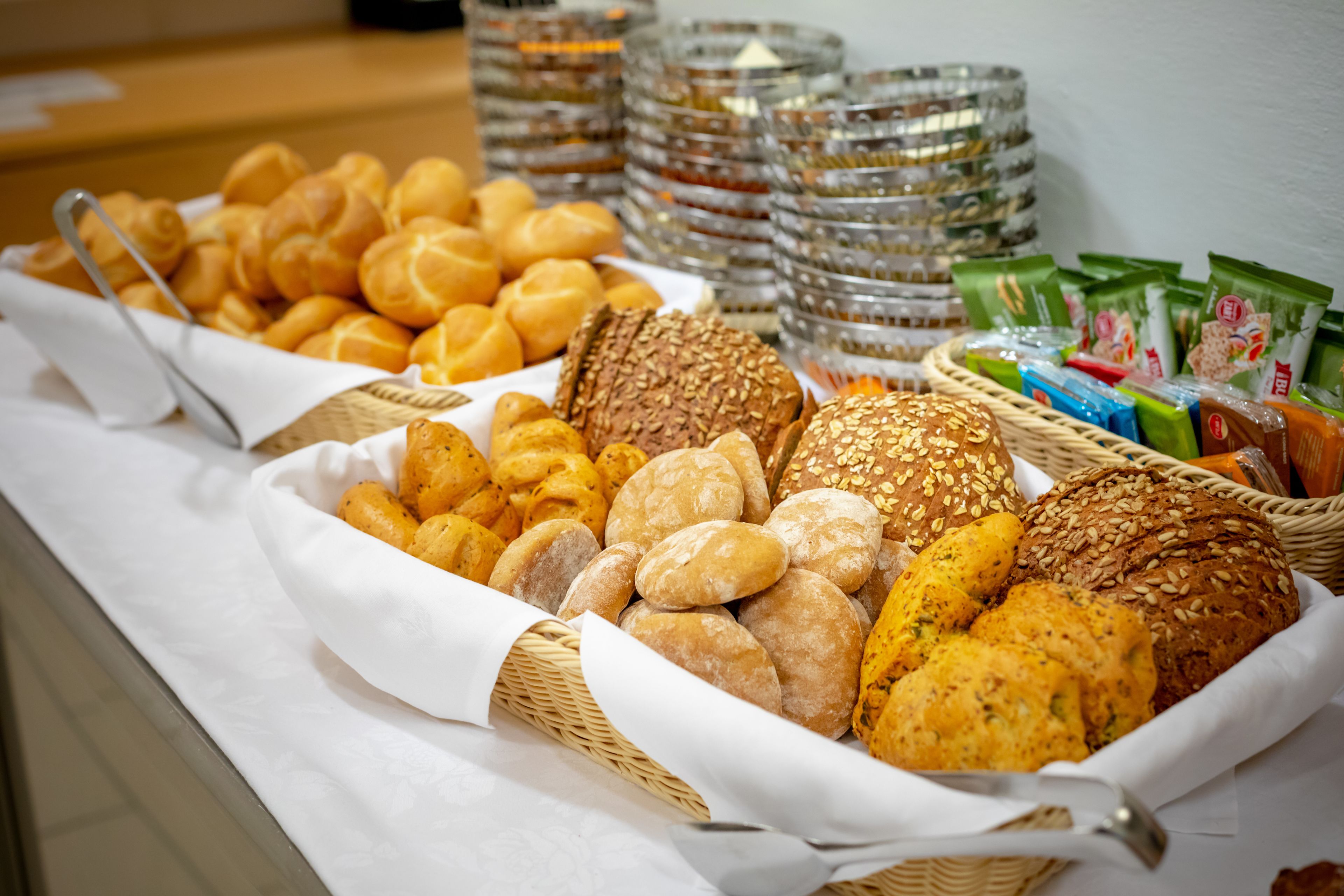 A buffet table with various breads and pastries.