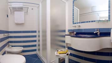 A bathroom with a toilet, bidet, and shower stall.