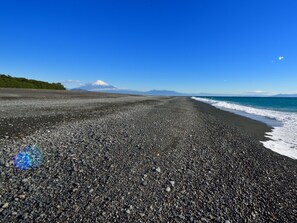 A pebbly beach with a mountain in the background and a clear blue sky. - Hotel Hagoromo (Shizuoka)
