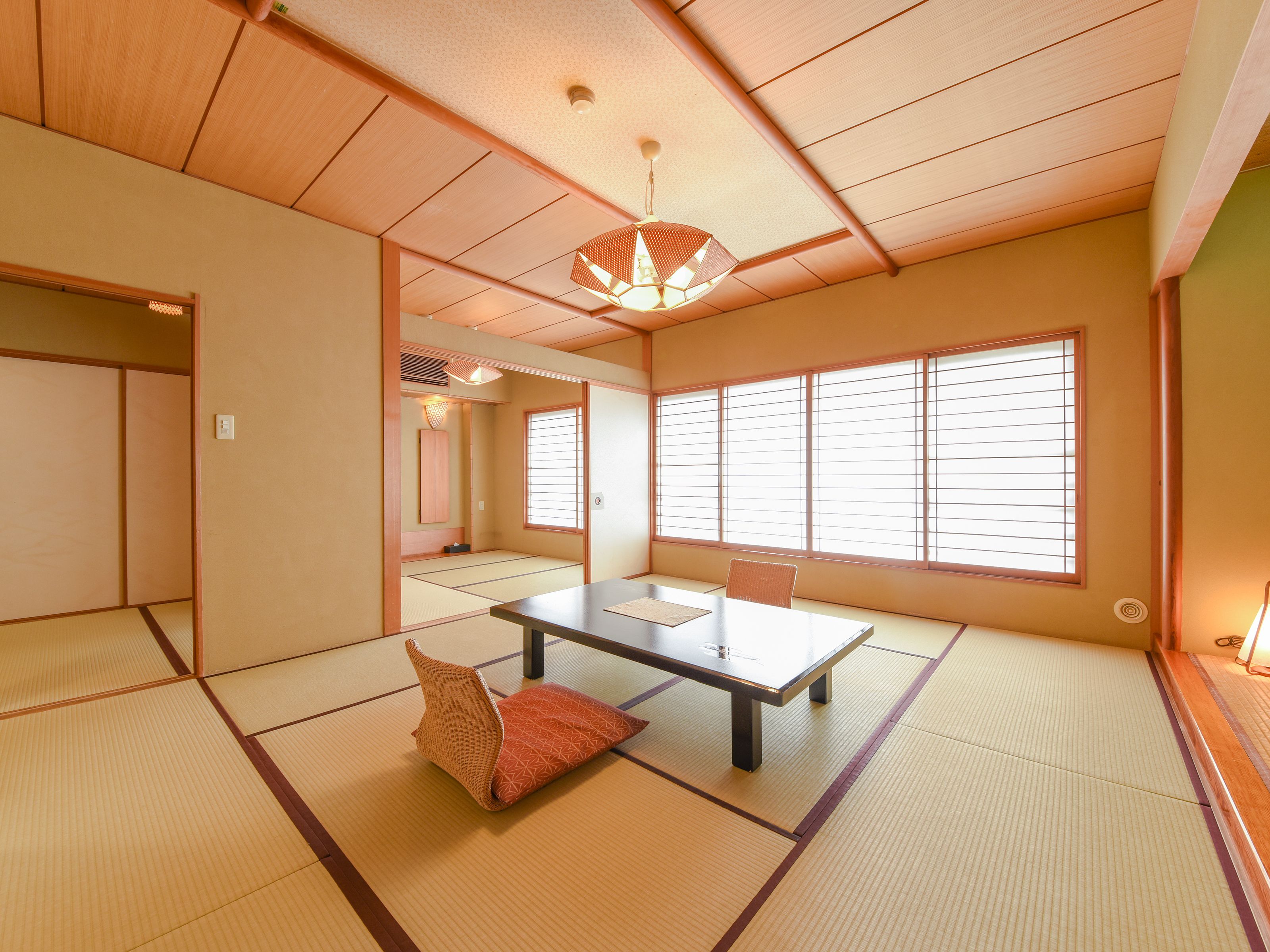 Habitació japonesa tradicional amb fons de tatami, una taula baixa i portes corredisses.