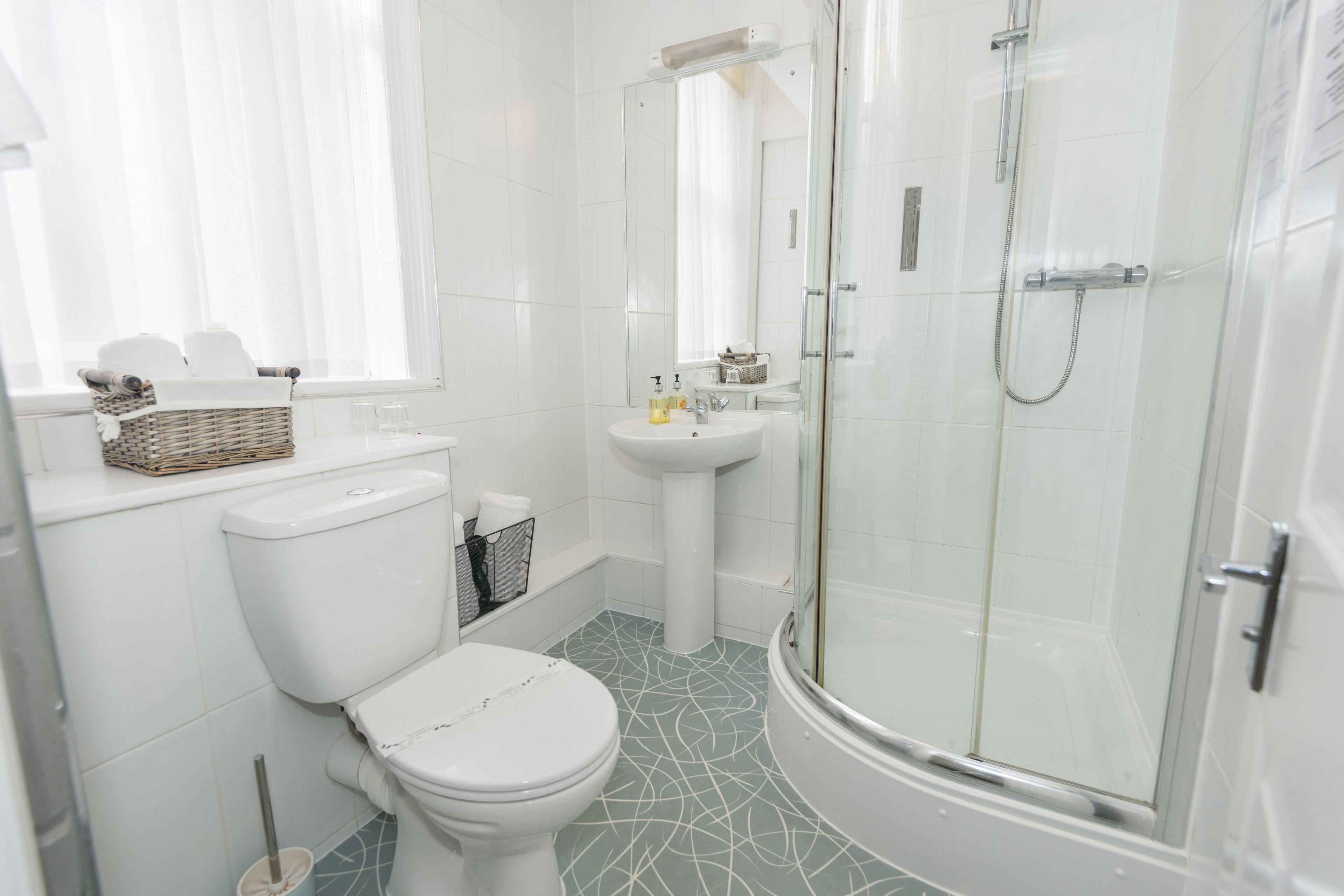 Een moderne badkamer met toilet, wastafel en douchecabine.