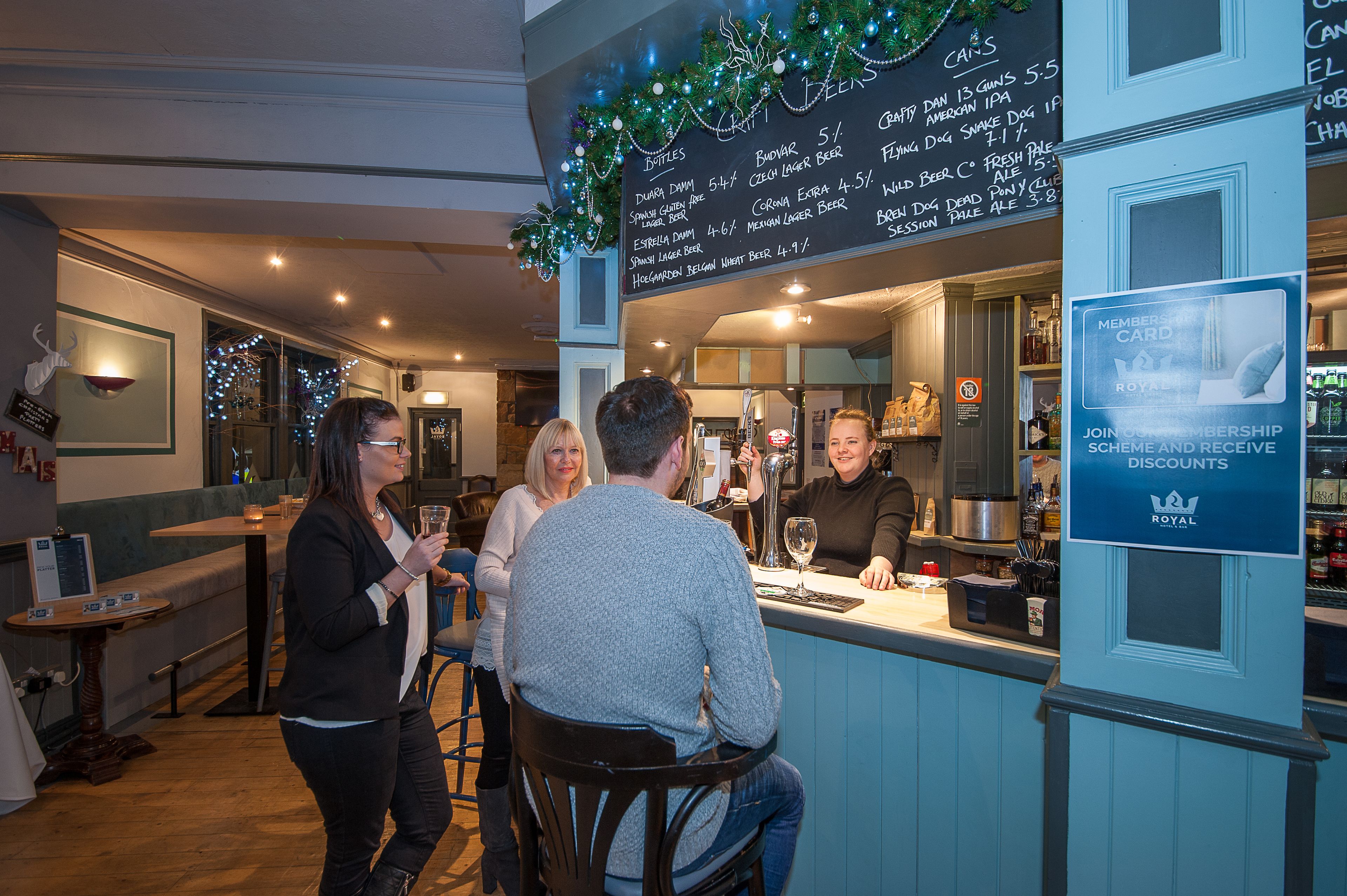A bar area with a menu board, bar counter, and seating.