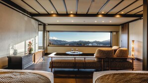 Una habitación moderna con un ventanal grande, un sofá, una mesita y una lámpara.