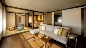 Una sala de estar moderna con un sofá modular, una mesa de centro de madera y una mesita auxiliar.