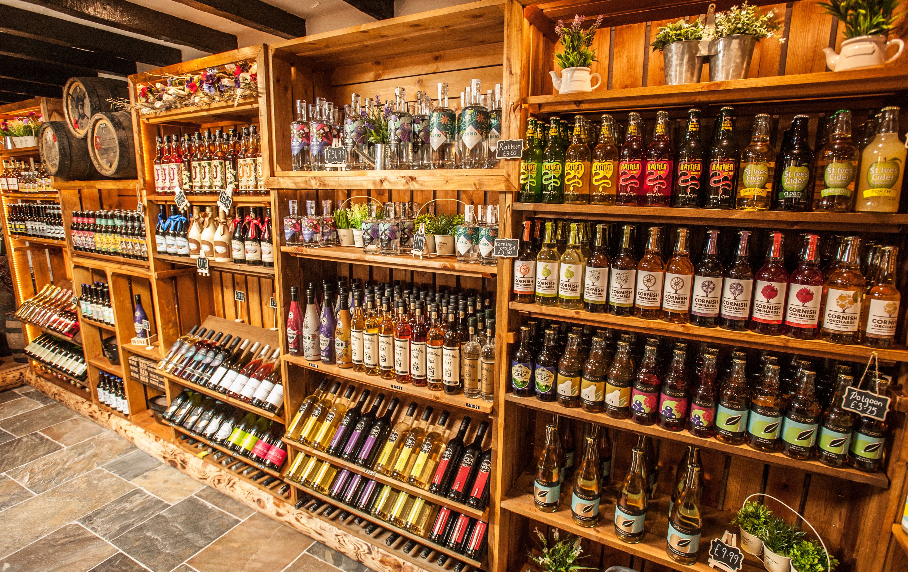 A variety of liquor bottles on wooden shelves in a store.