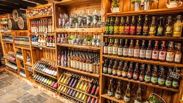 A variety of liquor bottles on wooden shelves in a store.