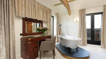 Un bagno con un mobile bagno in legno, una sedia, una vasca e uno specchio grande.