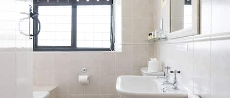 A modern bathroom with a toilet, sink, and shower.