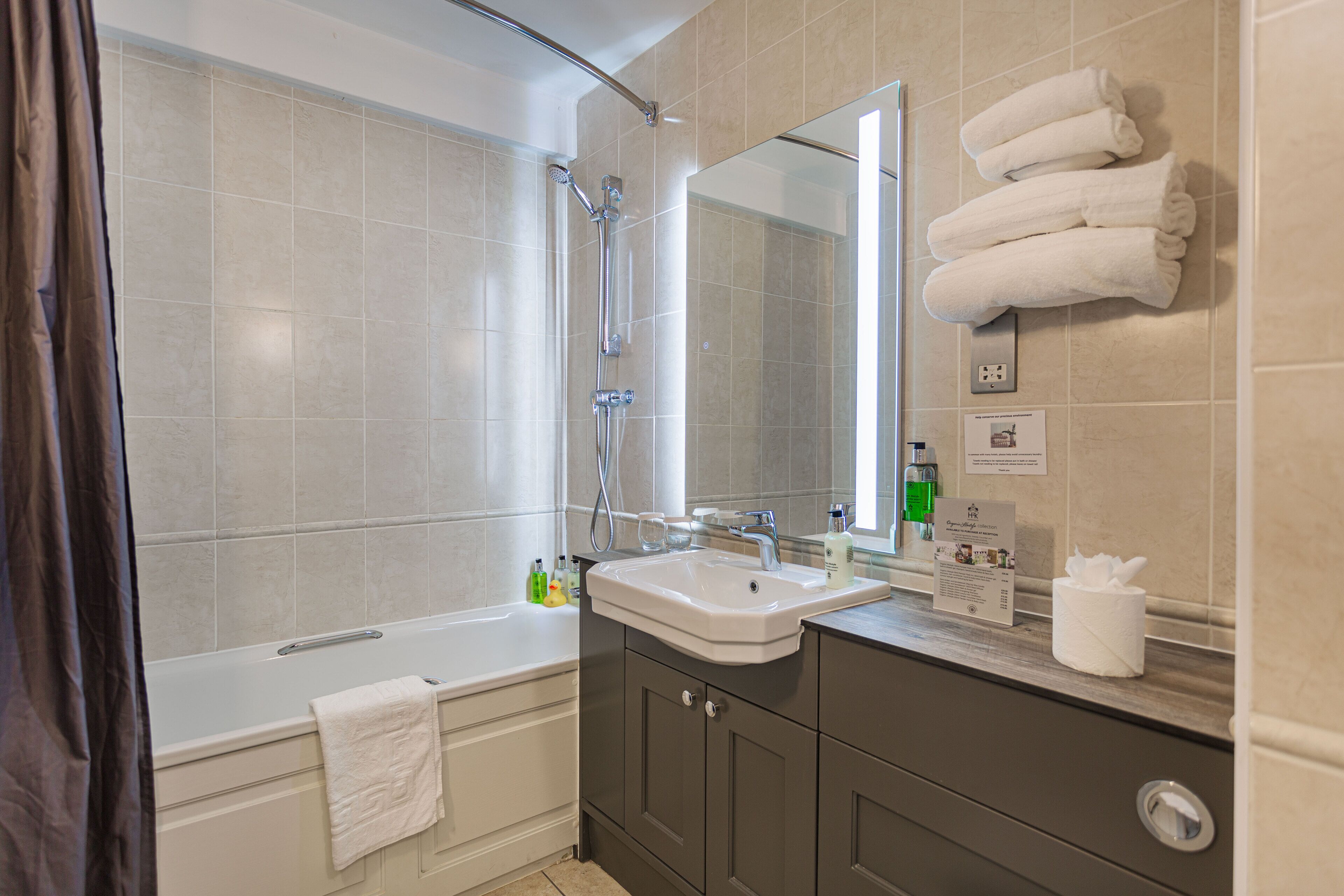 Un baño moderno con bañera, lavabo y espejo.