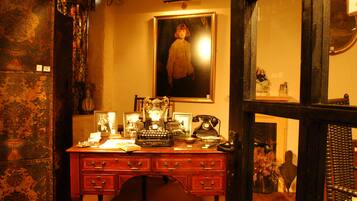 A vintage desk with a typewriter, a rotary phone, and a framed photograph.