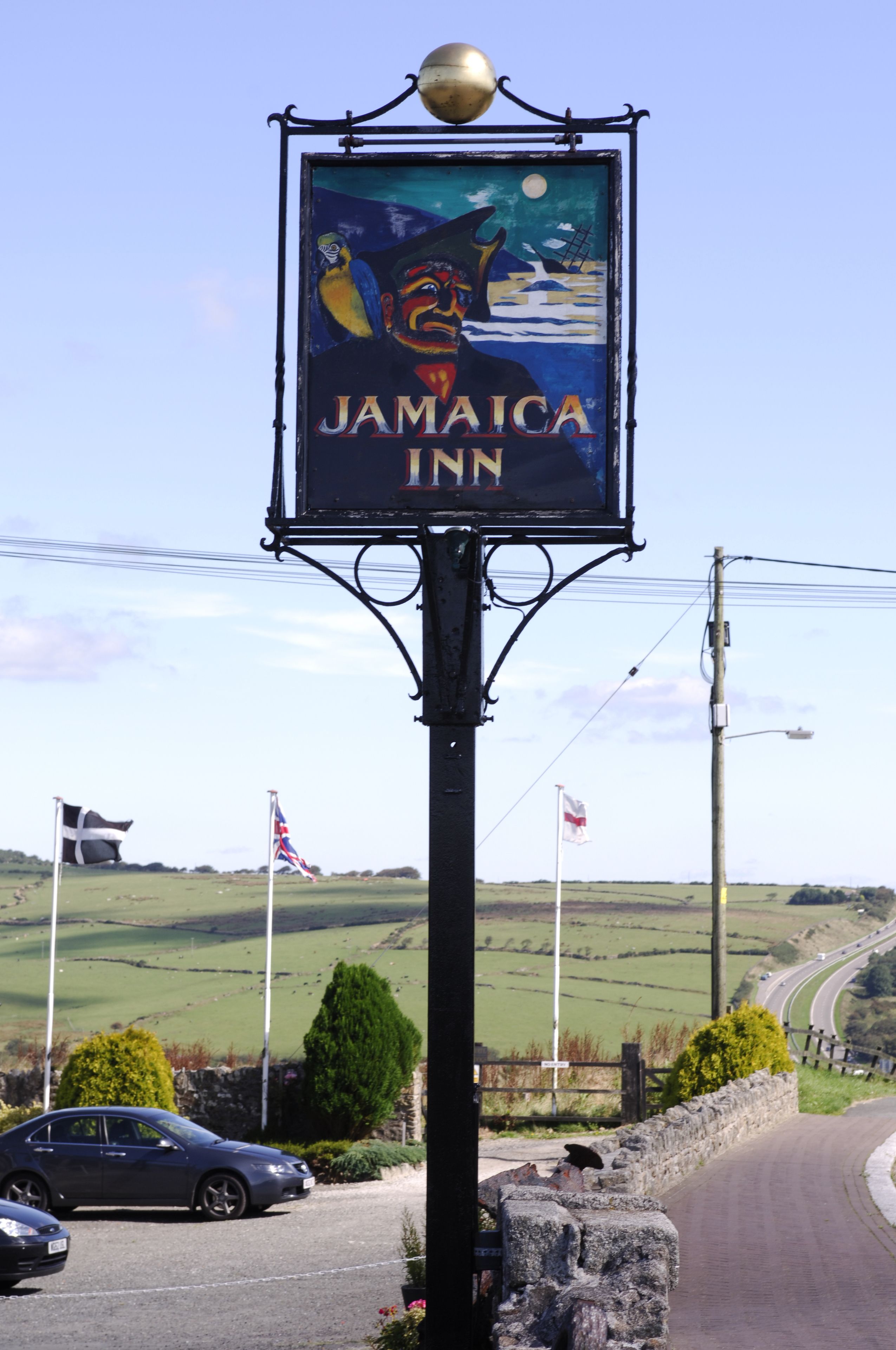 Señal de Jamaica Inn con una vista panorámica del campo.