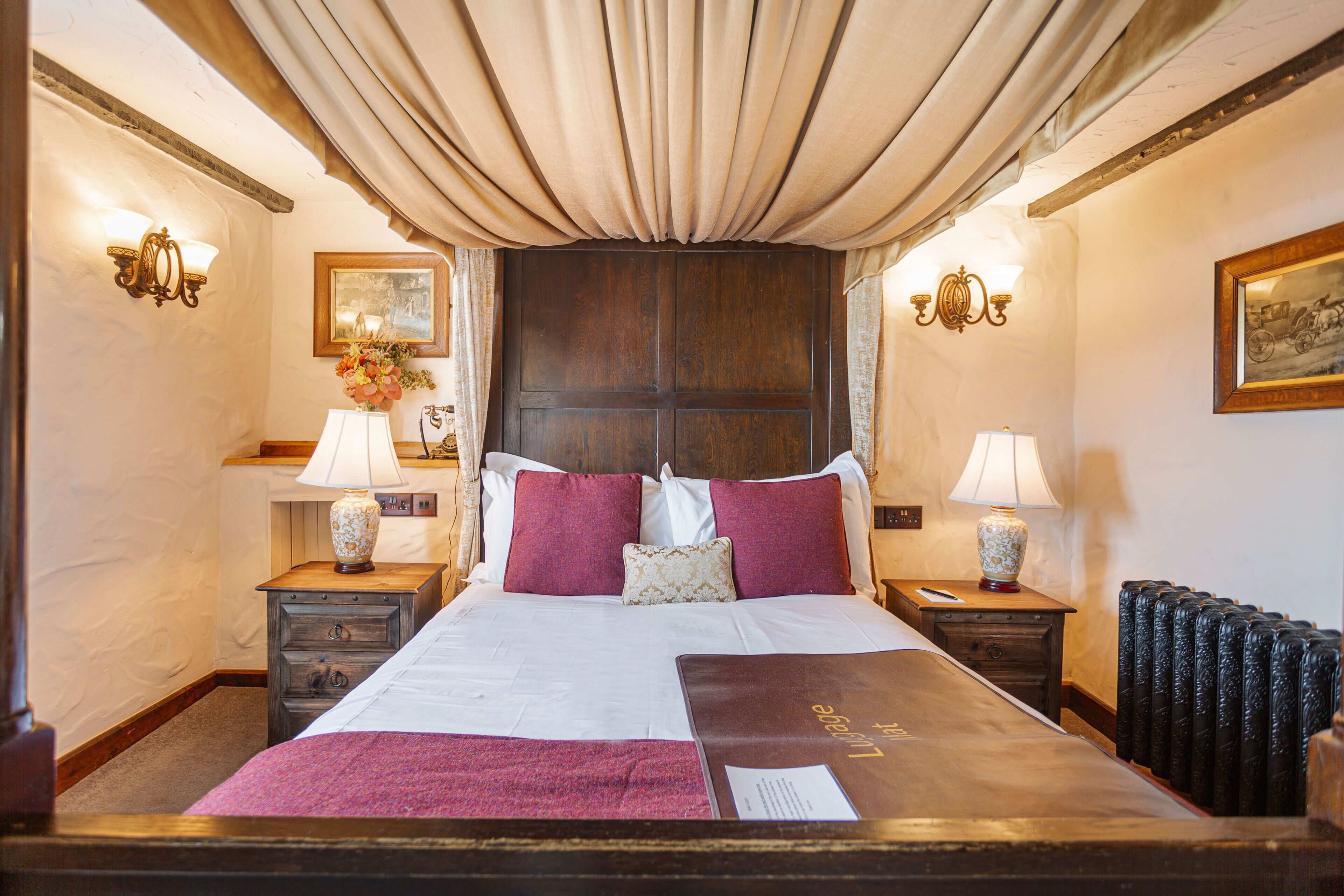 Une chambre d’hôtel avec un grand lit, deux tables de chevet, un radiateur et des lampes fixées au mur.