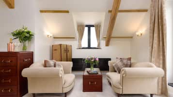 Deluxe Suite | Living room | 32-inch flat-screen TV with satellite channels, TV