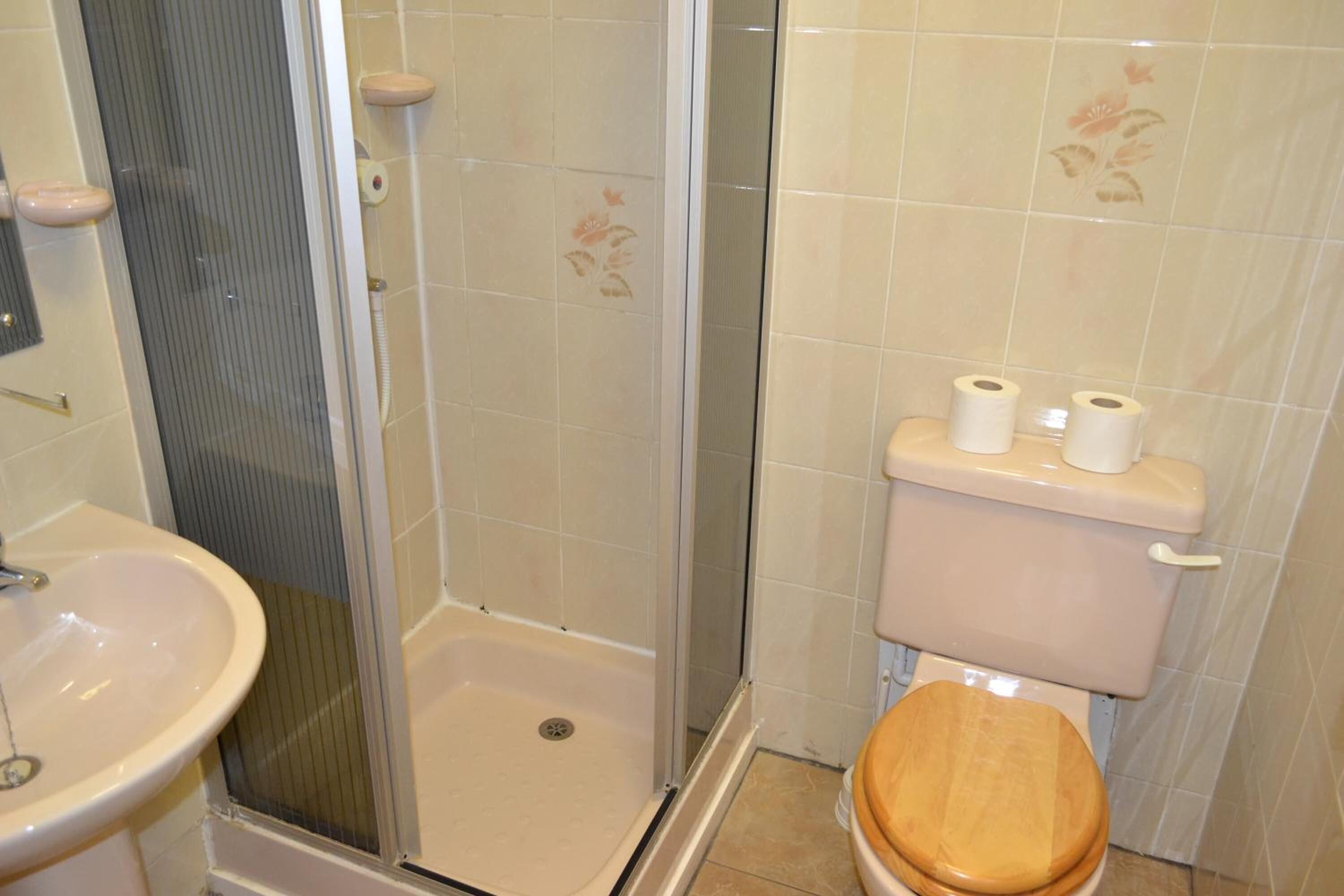 A bathroom with a shower, toilet, and sink.