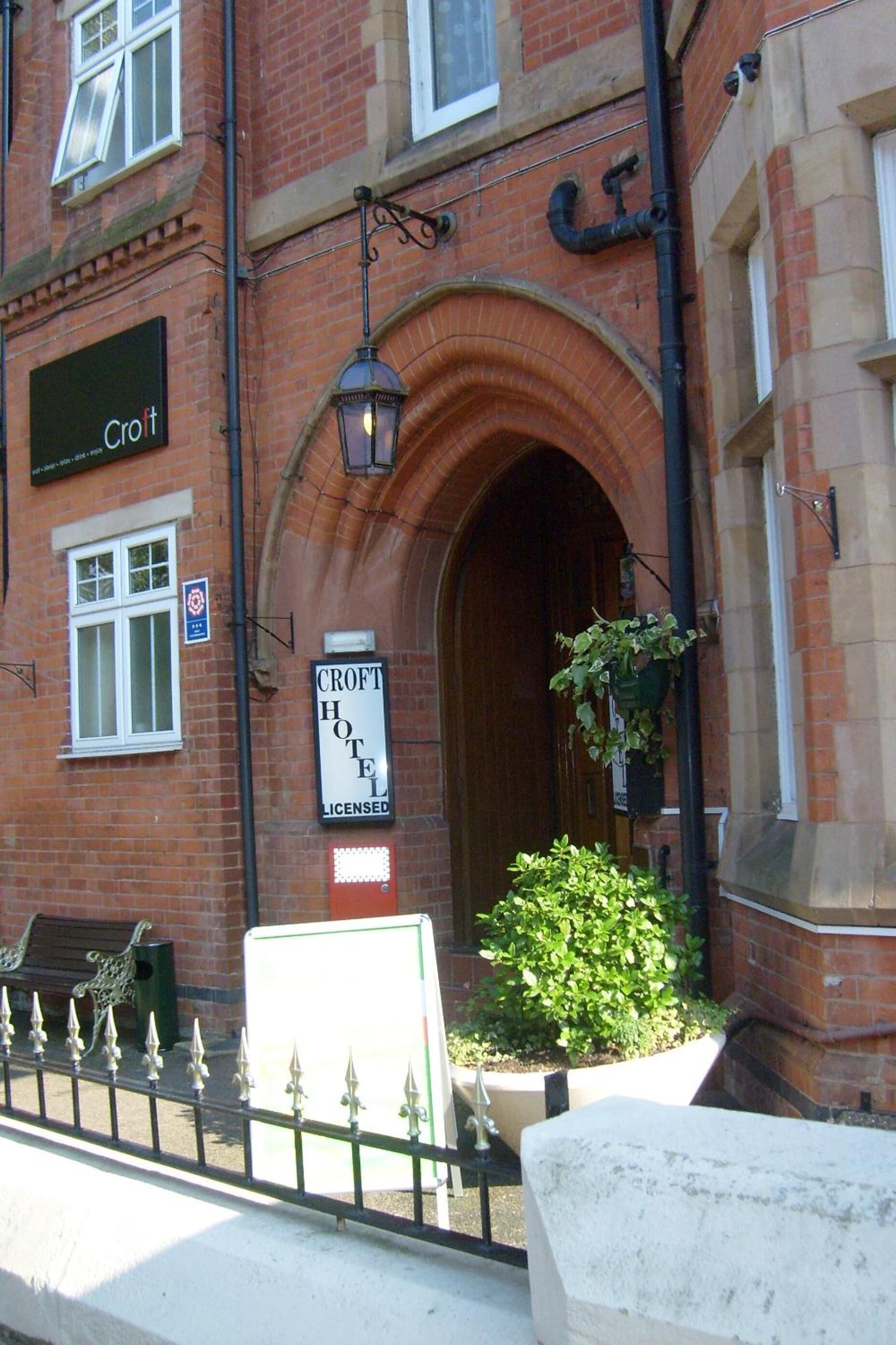 A brick building with a sign reading "Croft Hotel Licensed."