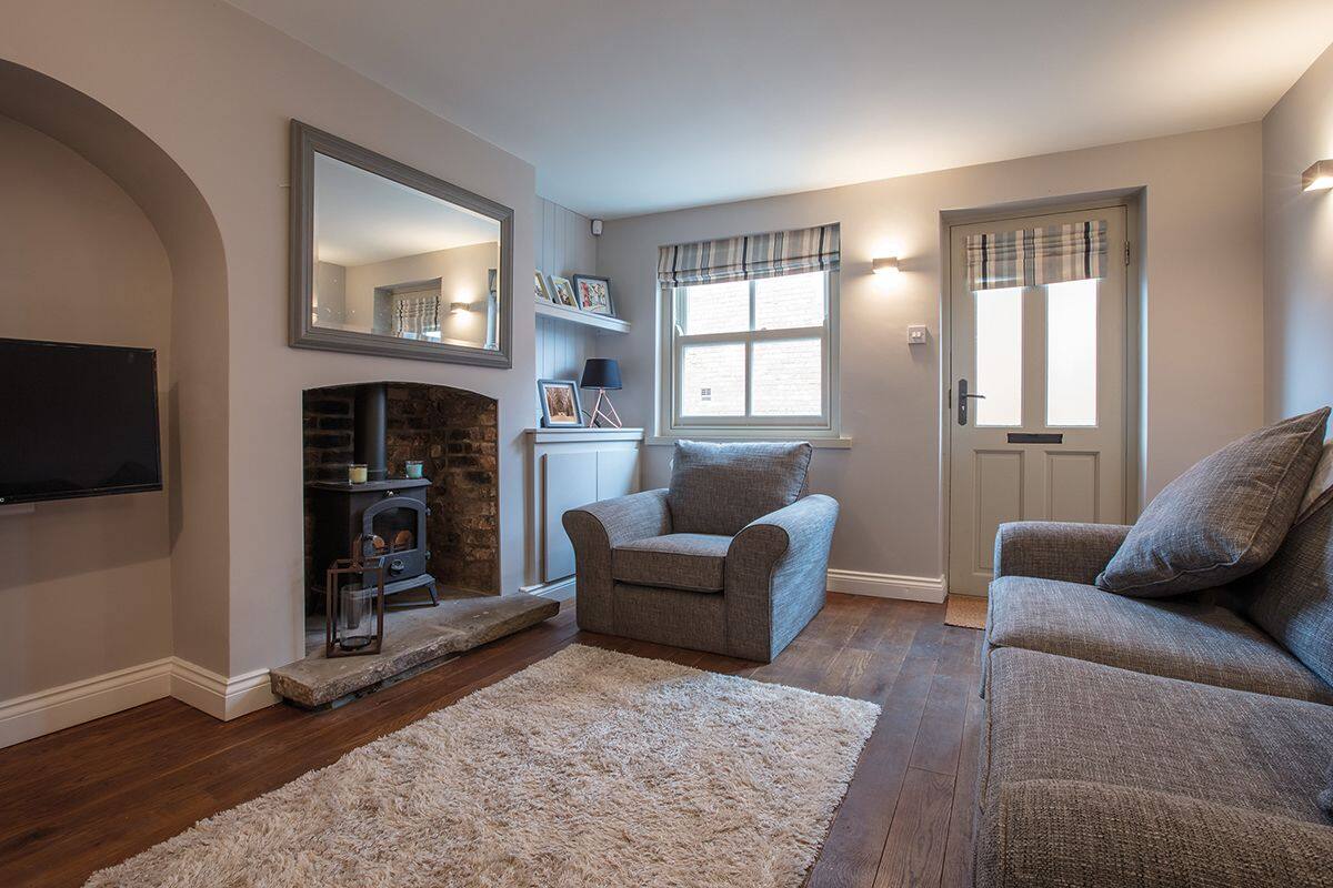 A living room with a fireplace, a sofa, a chair, and a television.