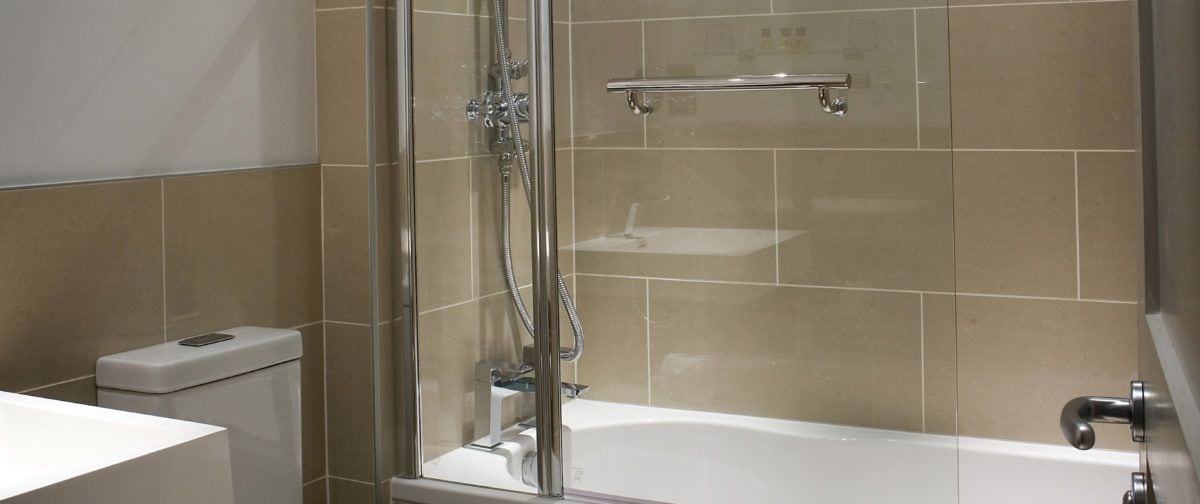 A modern bathroom with a glass-enclosed shower, a white toilet, and a bathtub.