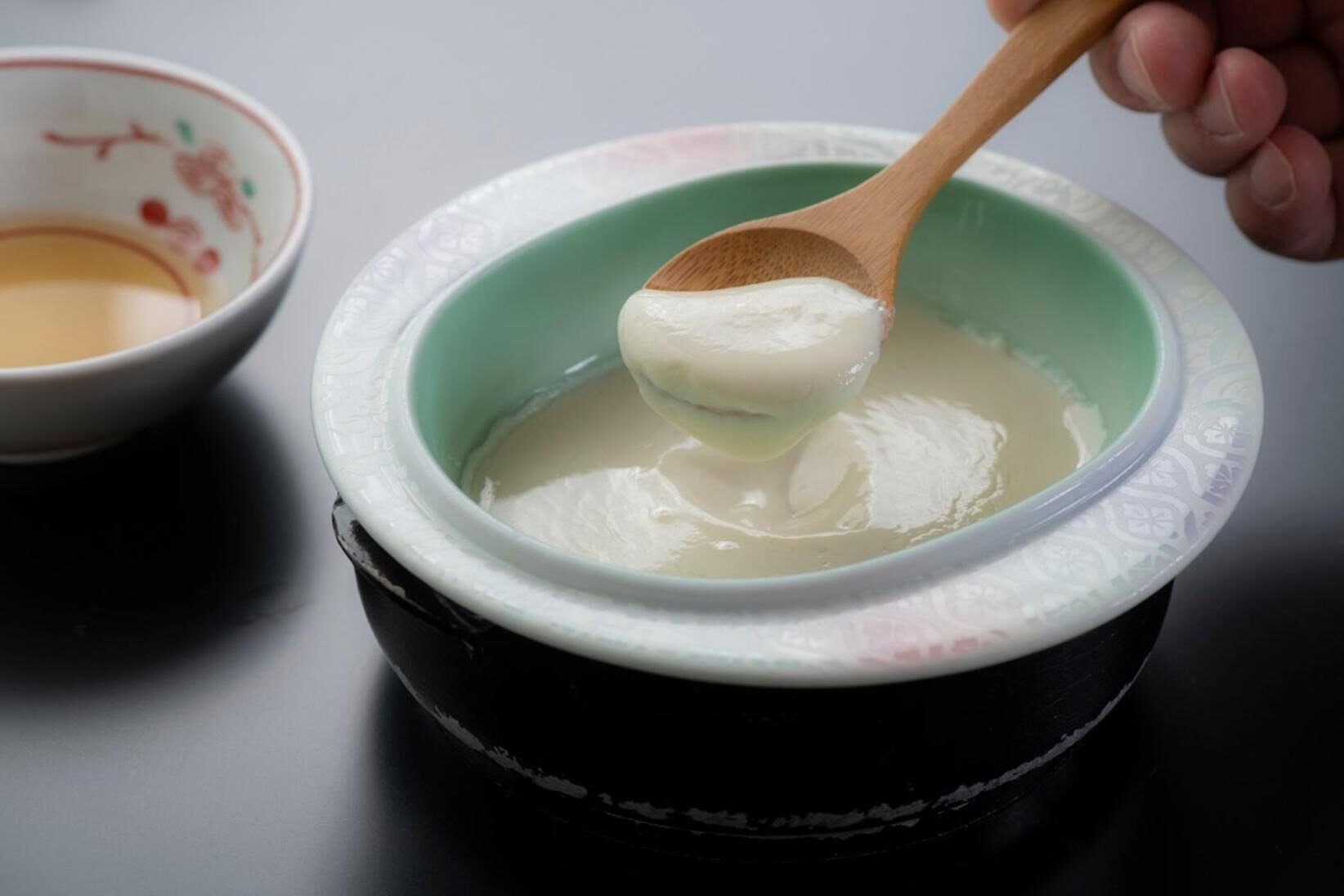 A bowl of white substance with a wooden spoon.
