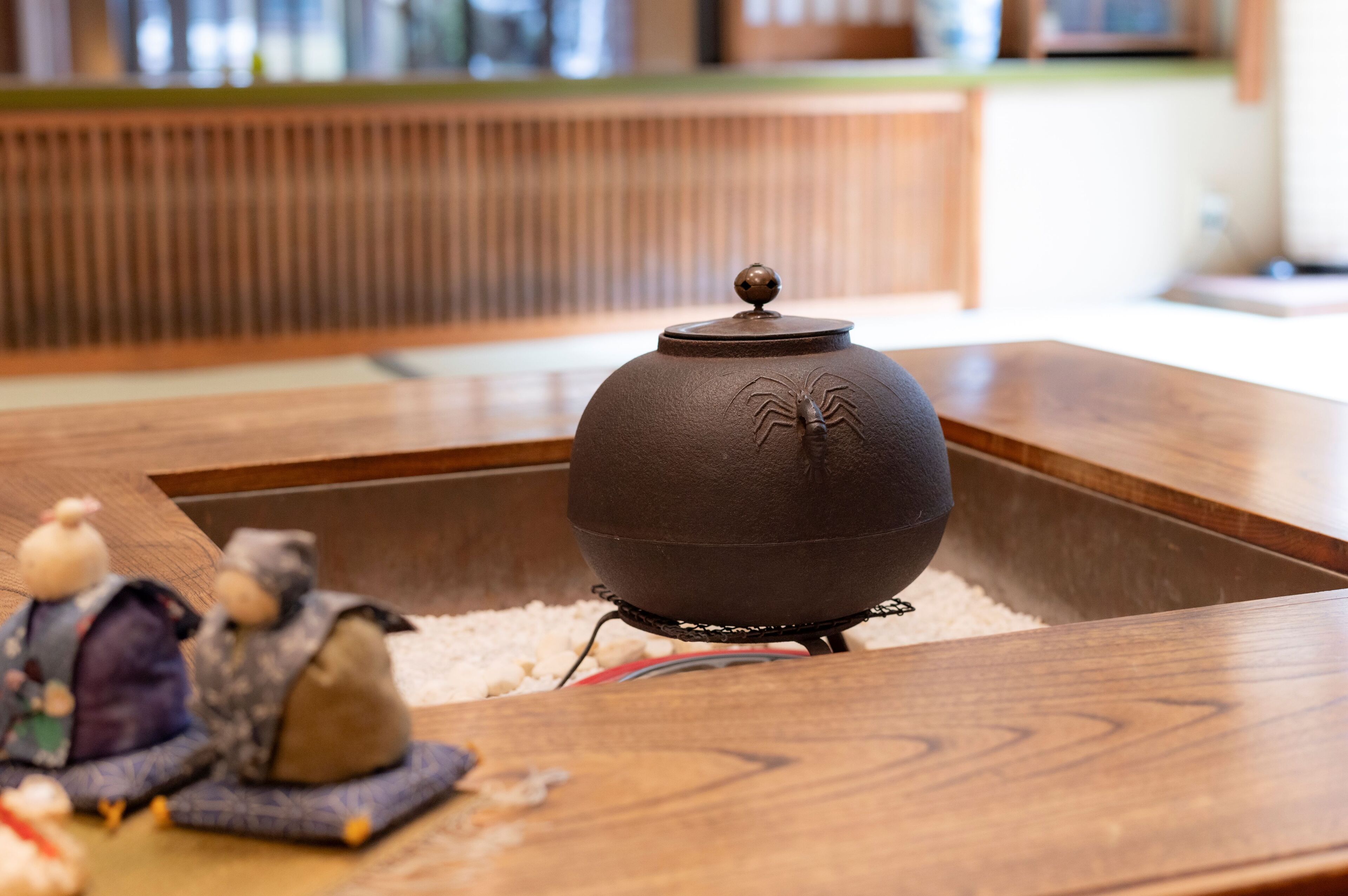 Disposición tradicional para una ceremonia del té japonesa, con una tetera sobre una mesa de madera, rodeada de esteras de tatami.