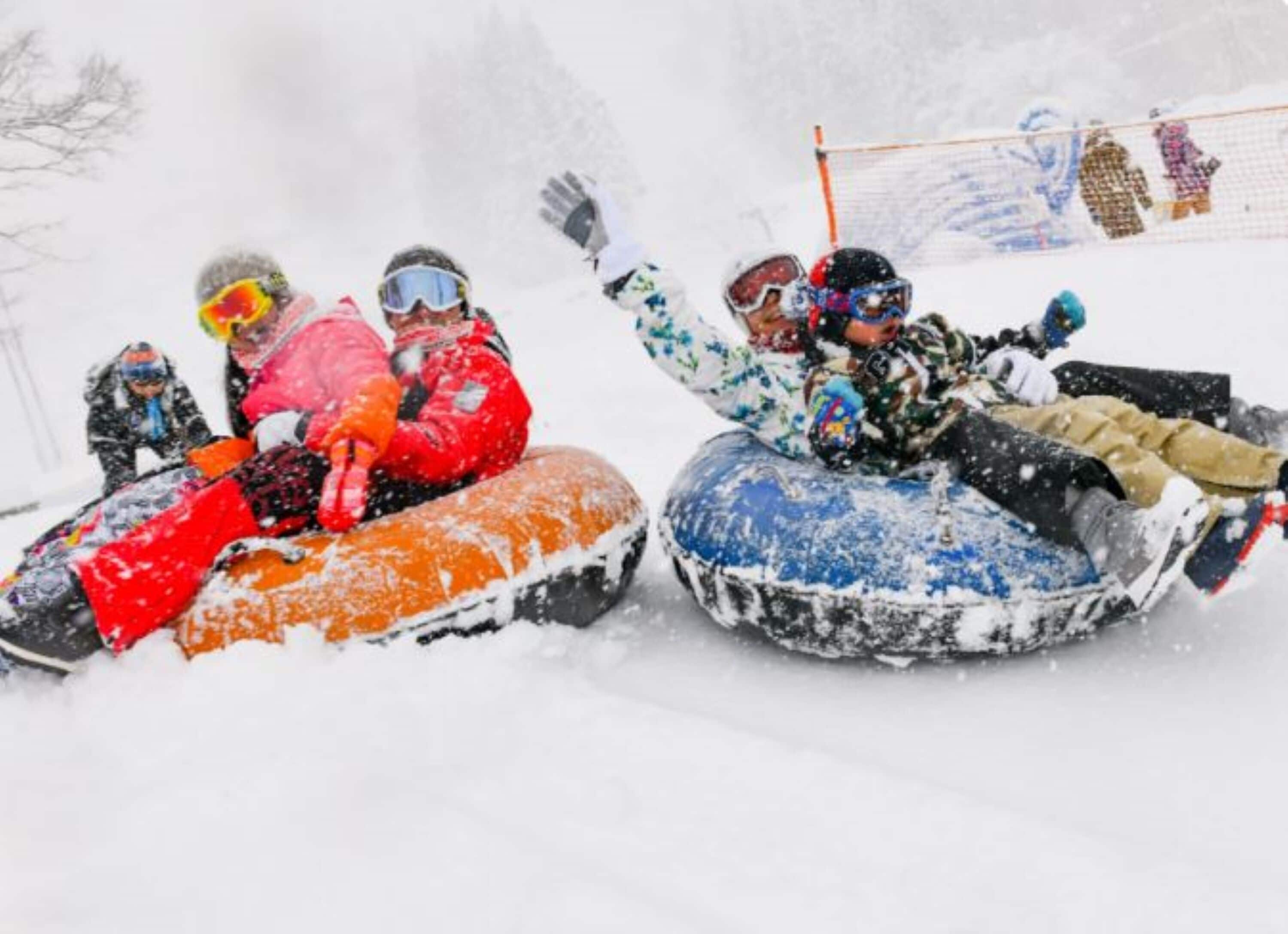 People sledding down a snowy slope.