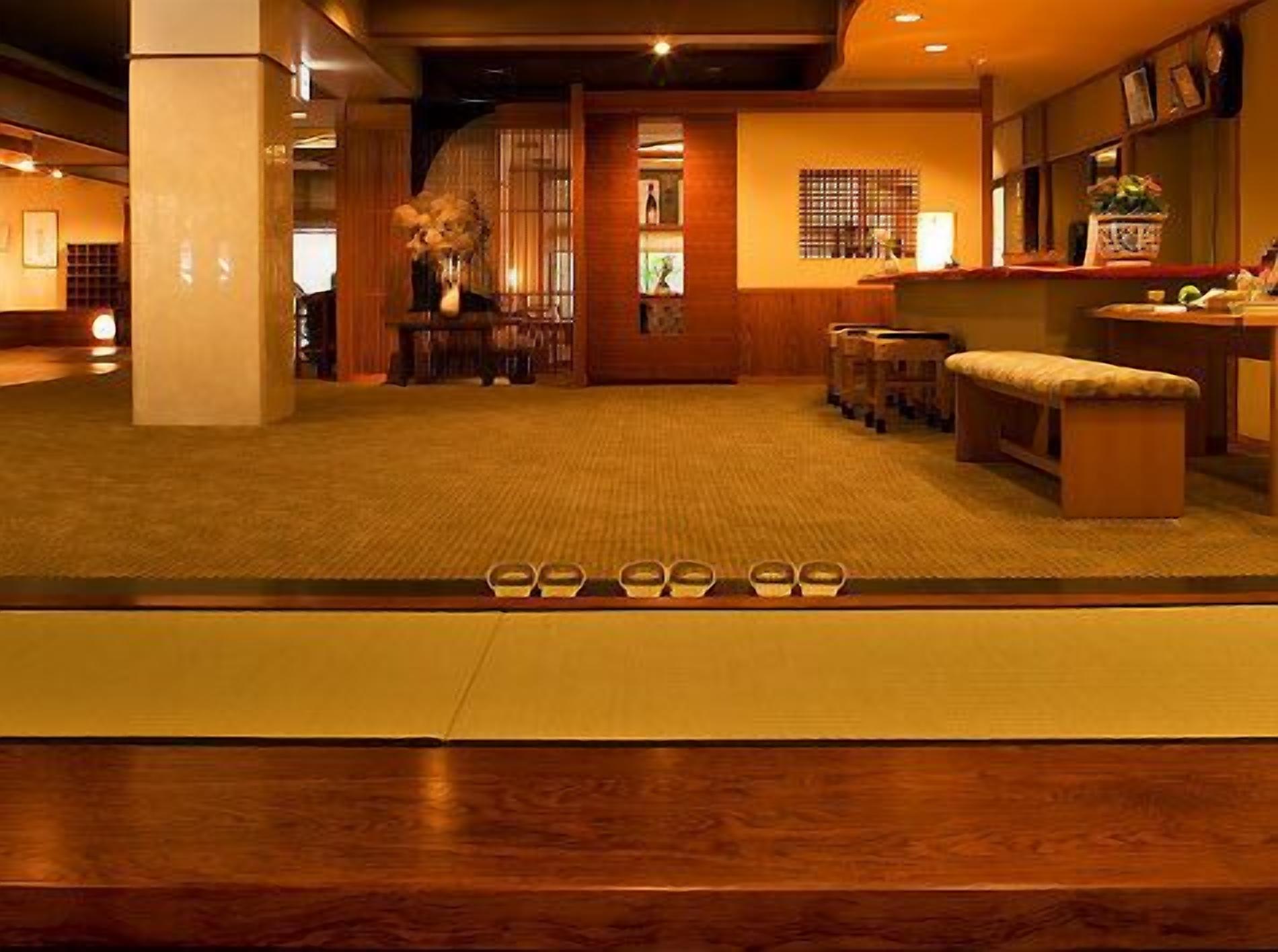 A hotel lobby with a reception desk, seating area, and a decorative vase.