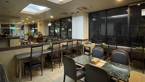 A restaurant with a bar area, seating, and large windows. - Crystal Hiroshima (Hiroshima)