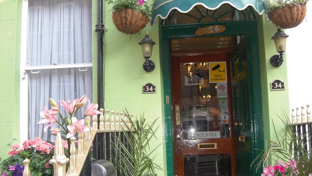 The exterior of the Albany Hotel, featuring a green facade, a number 34 sign, and a 'CCTV in operation' sign. - Albany Hotel (London)