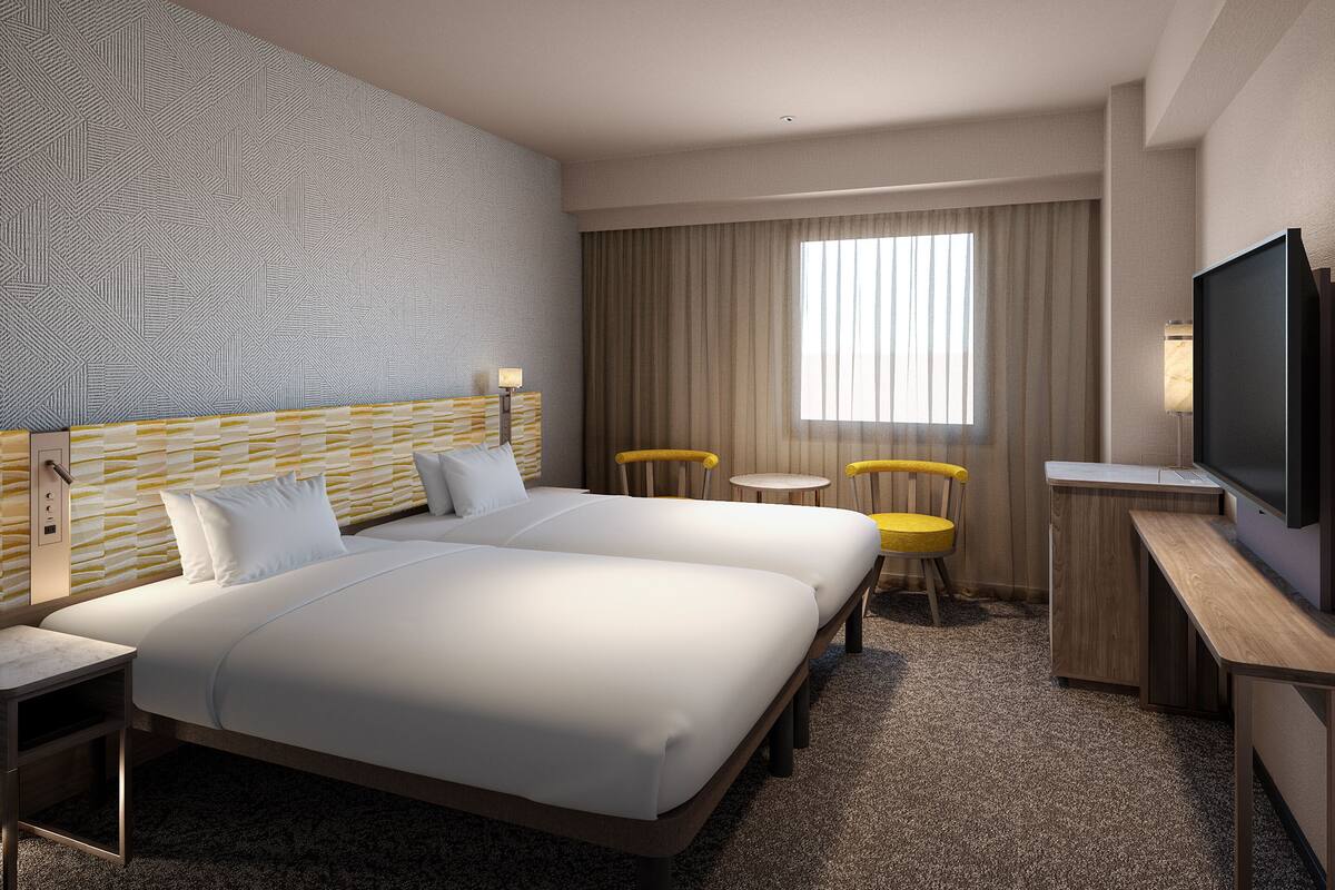 Habitación de hotel con una cama grande, dos mesitas de noche, un escritorio con silla, televisor y una ventana con cortinas.