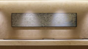 A wall-mounted flat-screen TV with a textured background.
