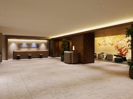 Un vestíbulo de hotel con mostrador de recepción, zona de estar y un amplio mural.