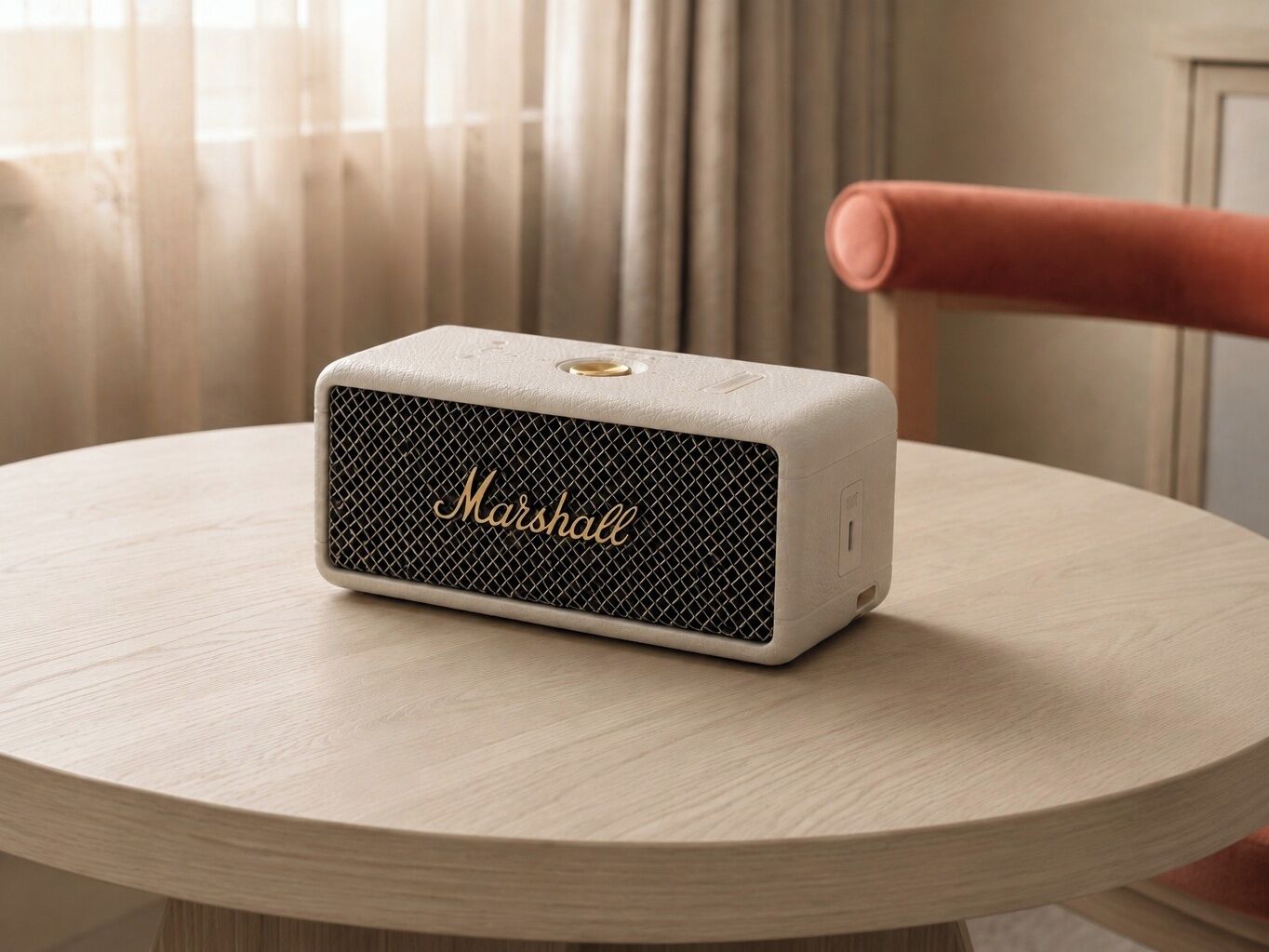 A Marshall portable speaker on a round wooden table.
