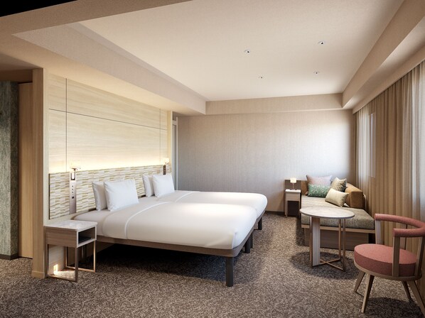 Een moderne hotelkamer met een groot bed, een zithoek met een kleine tafel en een losse stoel.