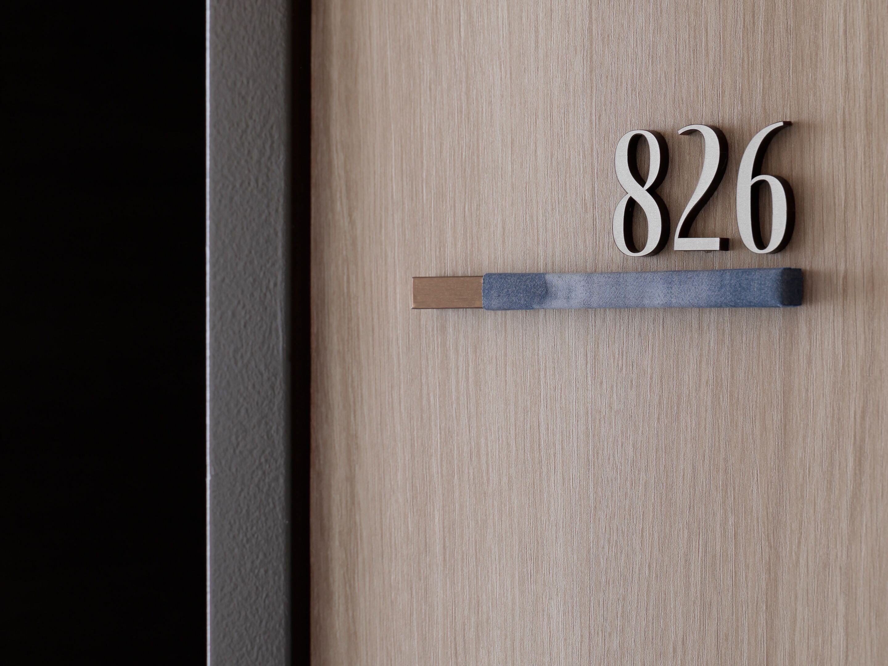 A wooden door with the number '826' and a blue handle.