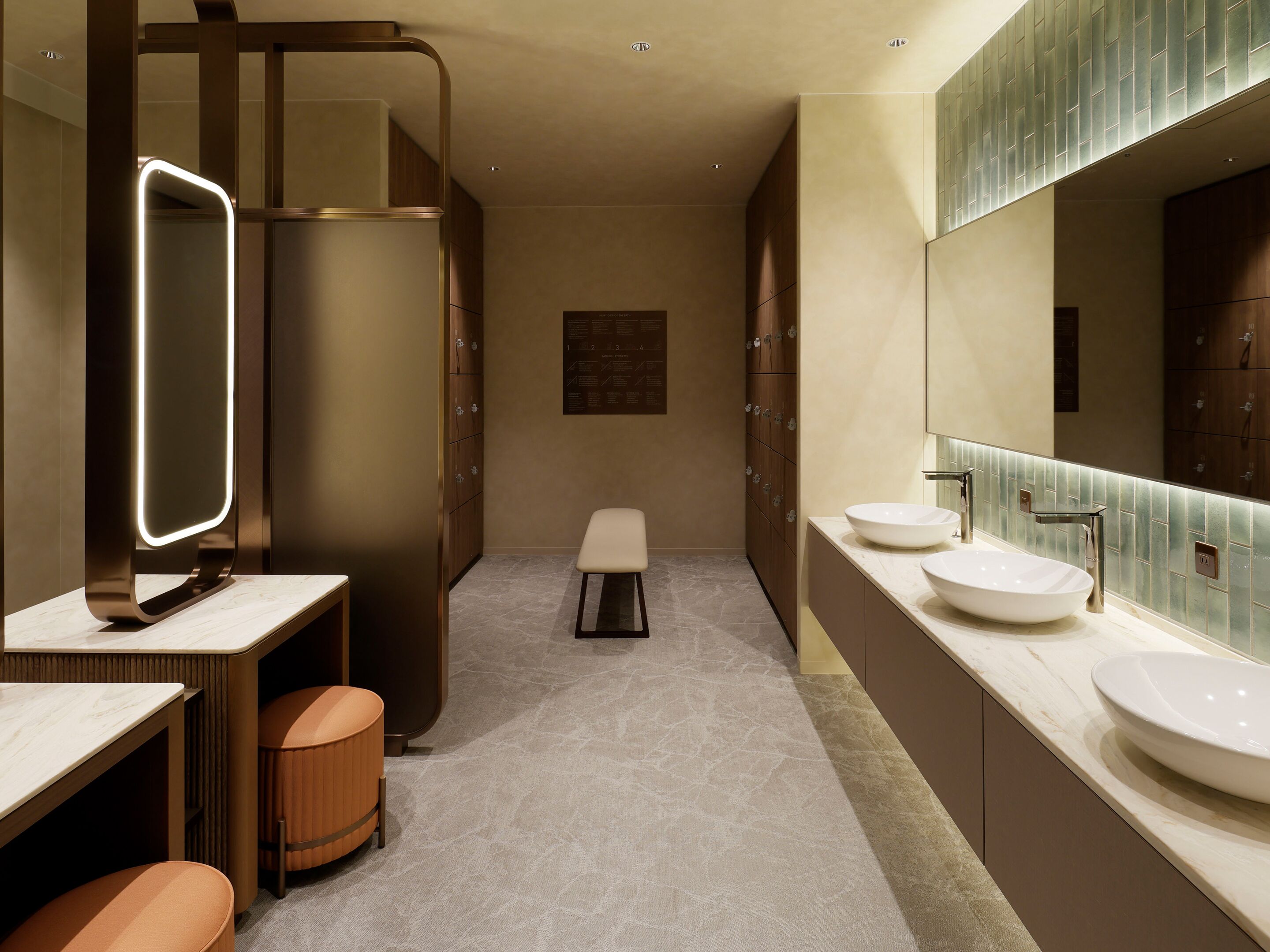 Un baño moderno con dos lavamanos, un espejo grande y una zona de estar.