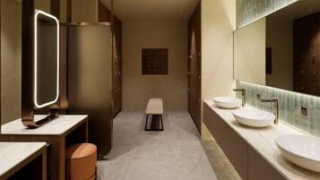 Un baño moderno con dos lavamanos, un espejo grande y una zona de estar.