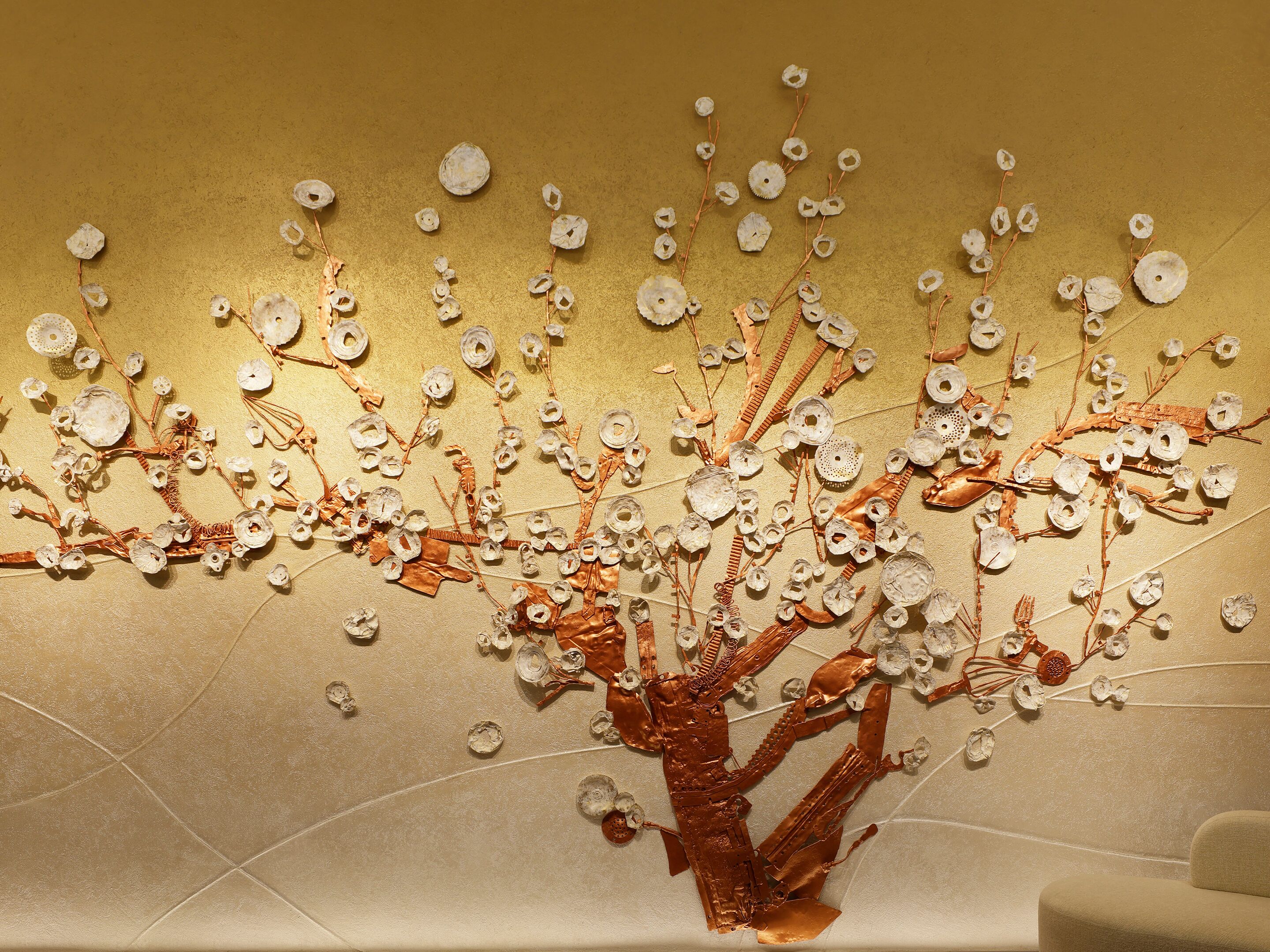 A wall with a decorative metal tree structure.