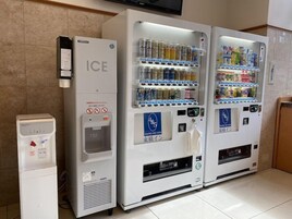 Una hilera de máquinas expendedoras con bebidas y hielo, incluyendo un dispensador de agua y una máquina de la marca 4&5.
