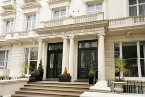 Fachada del Hotel Boutique Hyde Park con arquitectura clásica, incluyendo columnas y una entrada simétrica.